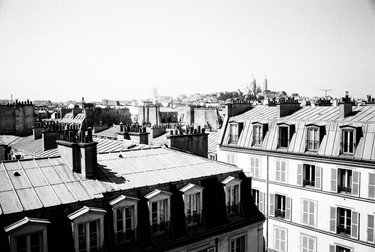 Le Sacré-Cœur blanc sur la butte, petit et décentré, dans la brume de chaleur, Les toits, Jeu 13 août 2026