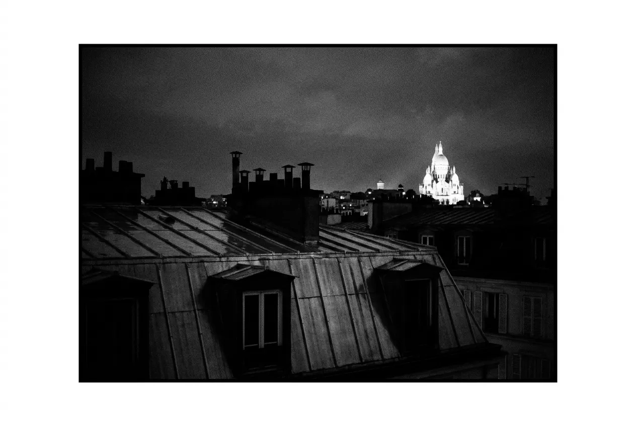 Le Sacré-Cœur éclairé la nuit, au loin, au-dessus des fenêtres noires, Les toits, Jeu 13 août 2026